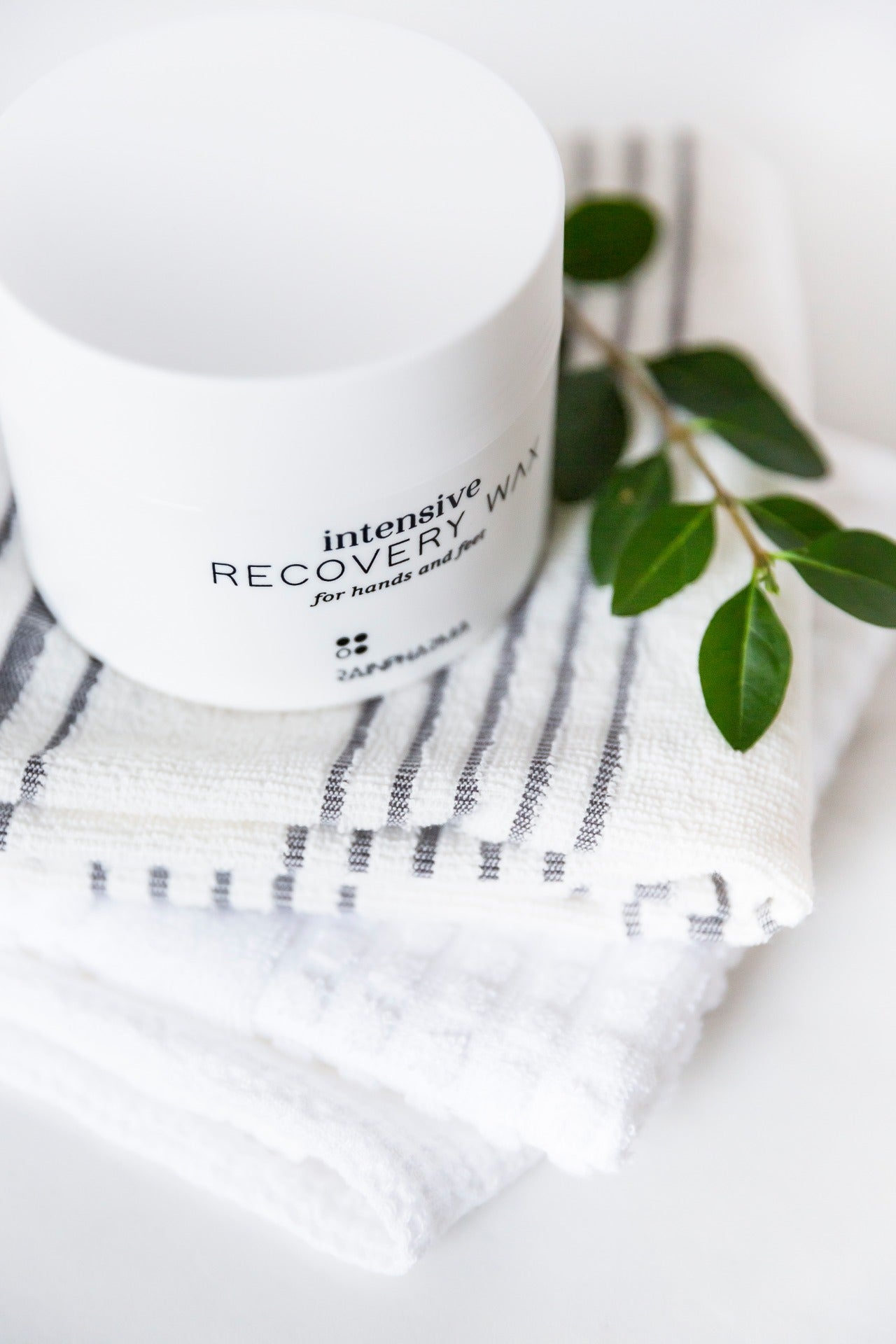 Intensive Recovery Wax van RainPharma via Studio Wuestenbergs. Deze wax is een intens voedende wax die gebarsten en beschadigde handen en voeten, al dan niet met kloven, helpt herstellen.