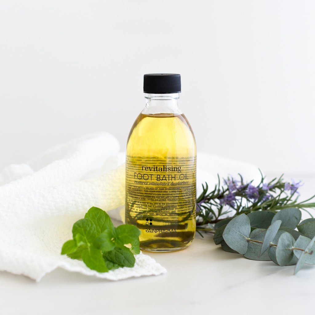 Revitalising Foot Bath Oil van RainPharma via Studio Wuestenbergs. Mentholkristallen ontgeuren, verfrissen en kalmeren vermoeide voeten. Cosmetische zuren verwijderen eelt en dode huidcellen voor een gezonde, zachte huid. Plantaardige oliën uit amandelen en druivenpitten verzachten, verzorgen en beschermen en zorgen voor de ontspannende finishing touch.